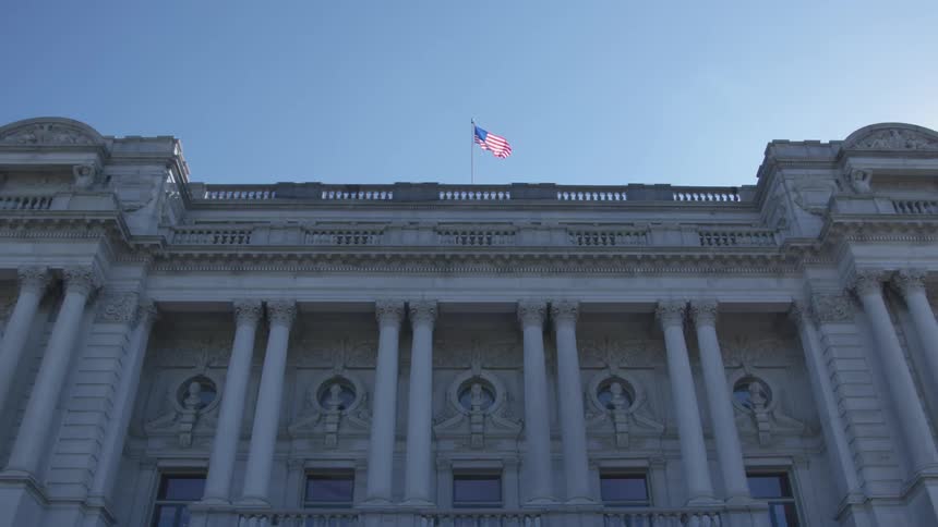 American flag flies over government building during the day