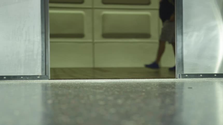 People walking by subway doors as they are closing
