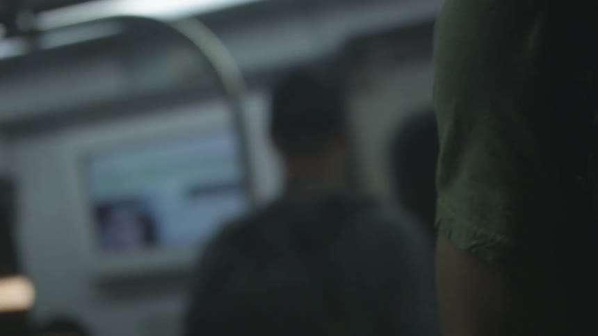 People sit and stand on a metro train