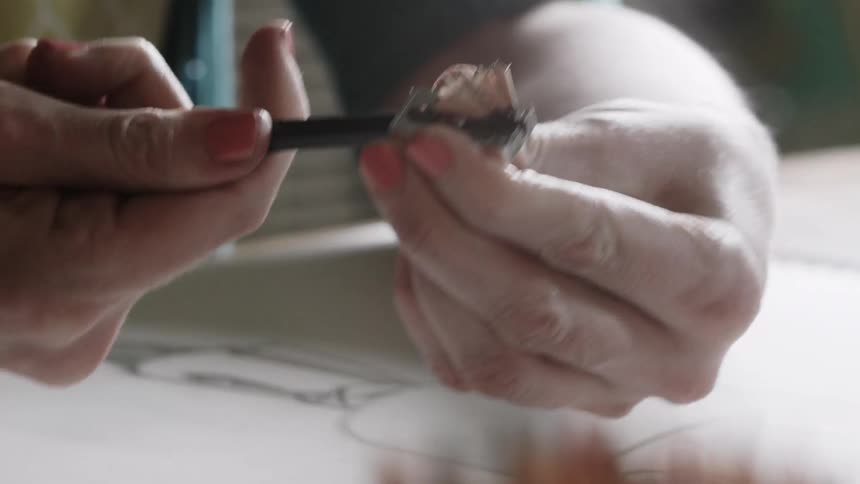An artist sharpens their pencil