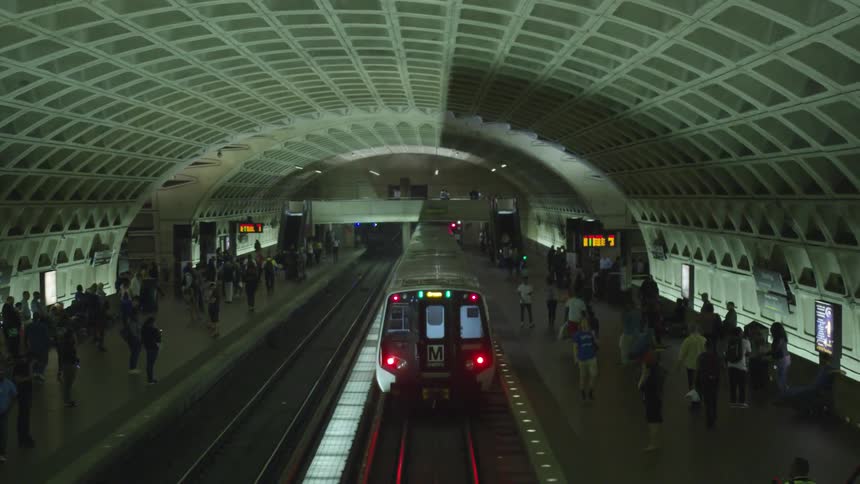 A train departs a subway station full of people