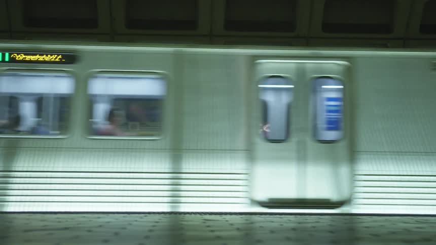 The subway full of passengers riding on the rails at the subway station