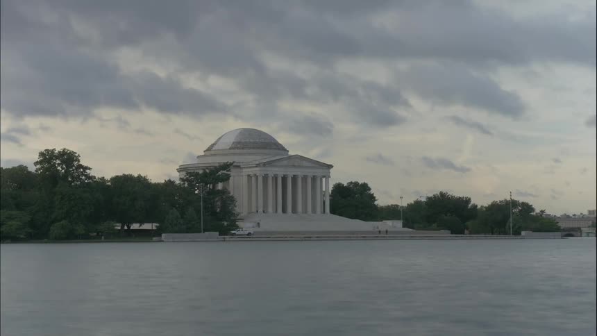 People visiting the jefferson memorial with clouds overhead