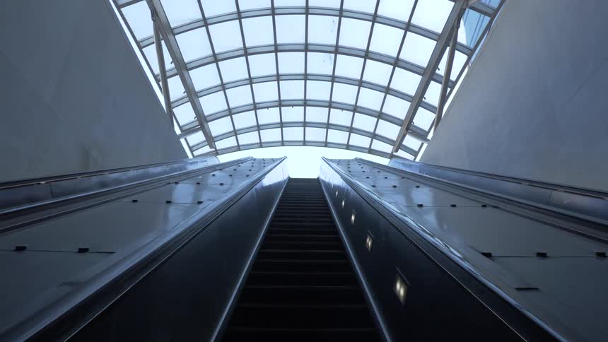 An unoccupied indoor escalator during the day