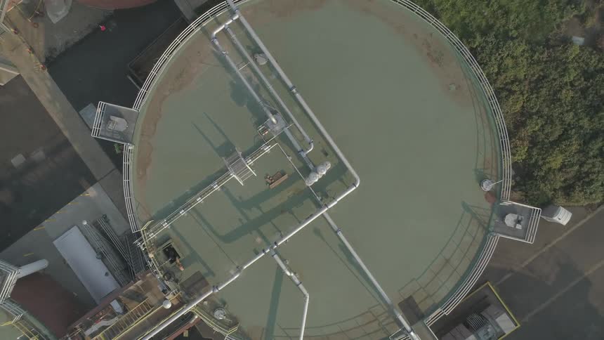 A fuel storage tank sits near a forest