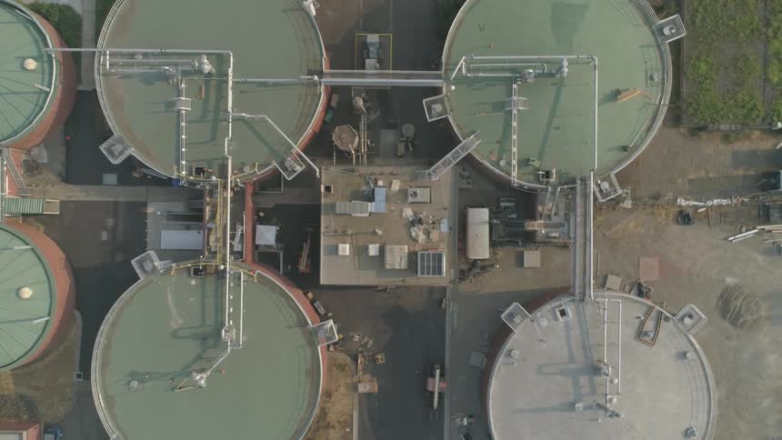 A building sits between several large fuel storage tanks