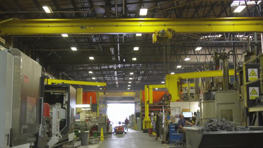 A factory with yellow beams that have rollers on them