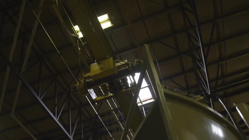 Crane operates on rails in warehouse