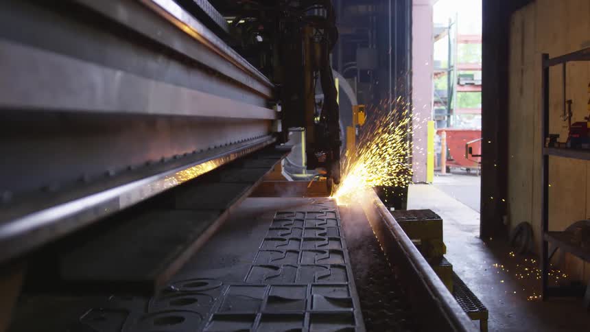 A piece of metal being welded on a welding machine