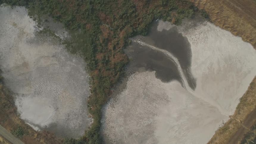 A frozen pond that is close to a road