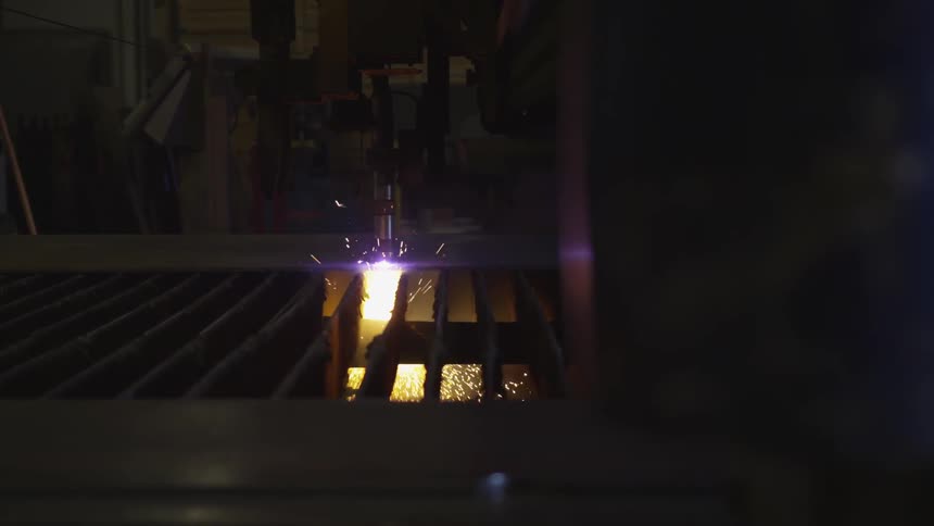 A machine is cutting through material in a dark room