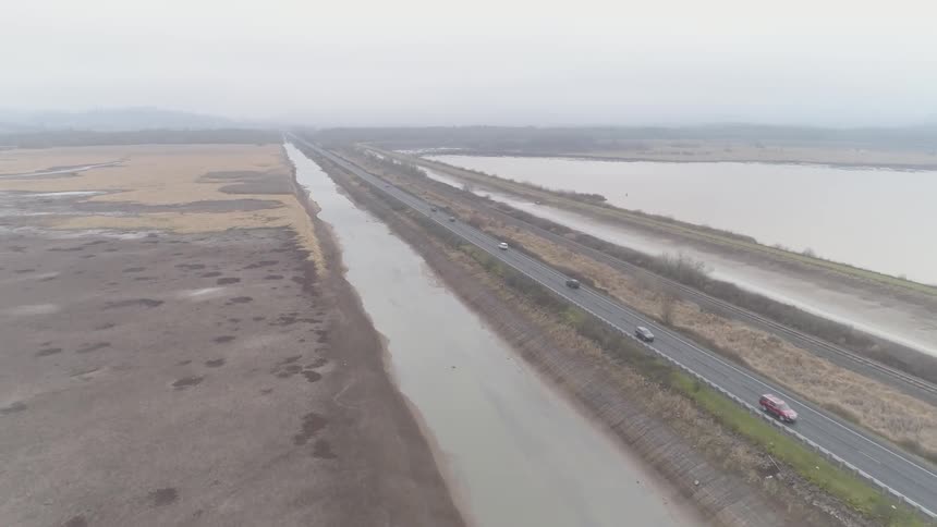 Cars driving down a highway near waterways