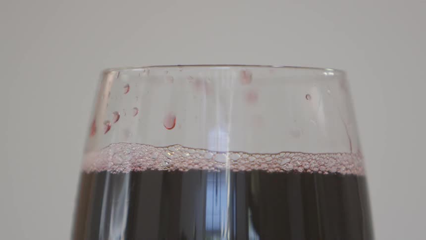 Beverage fizzes with bubbling in glass by day