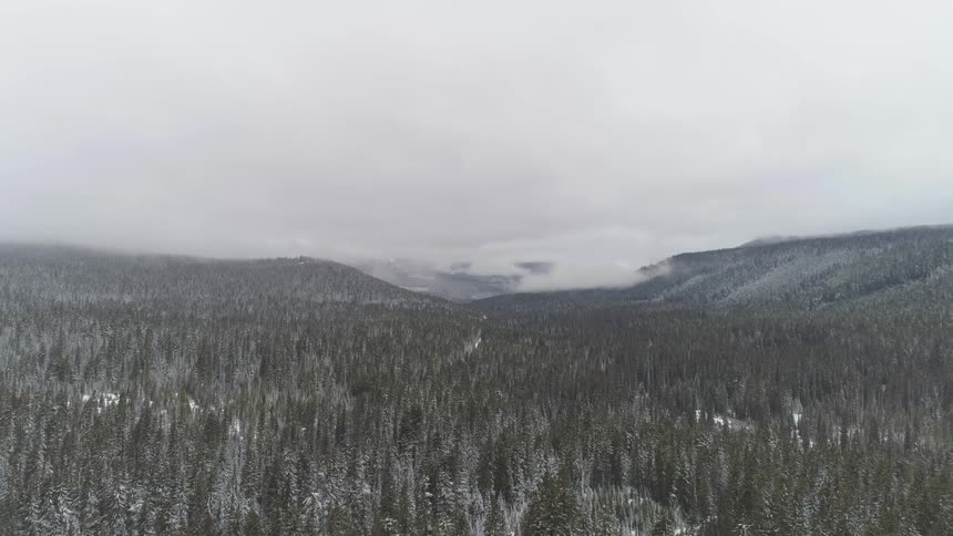 Mist rolling in over the mountain with patches of snow on the ground