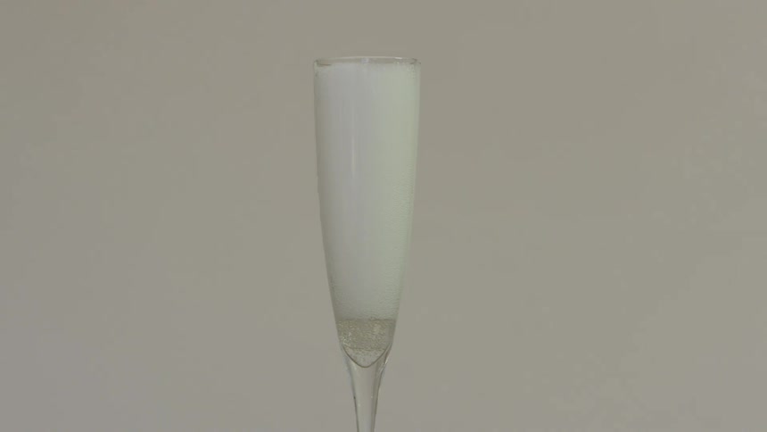 A wine glass being filled to the brim