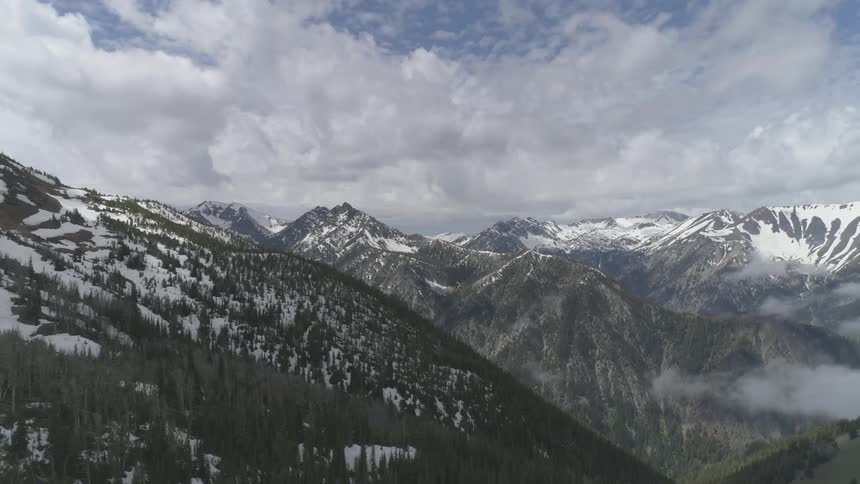 Clouds over snow capped mountains