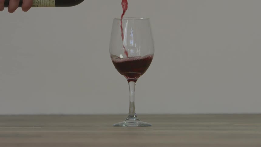 Red wine is poured into a glass