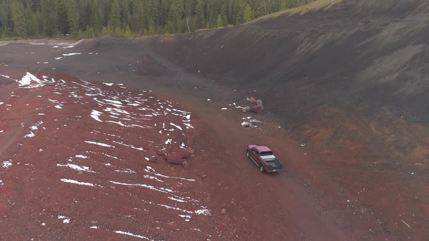 Truck drives in red and black quarry