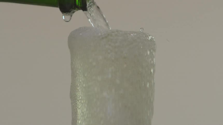 Liquid is being poured into a cup from a bottle