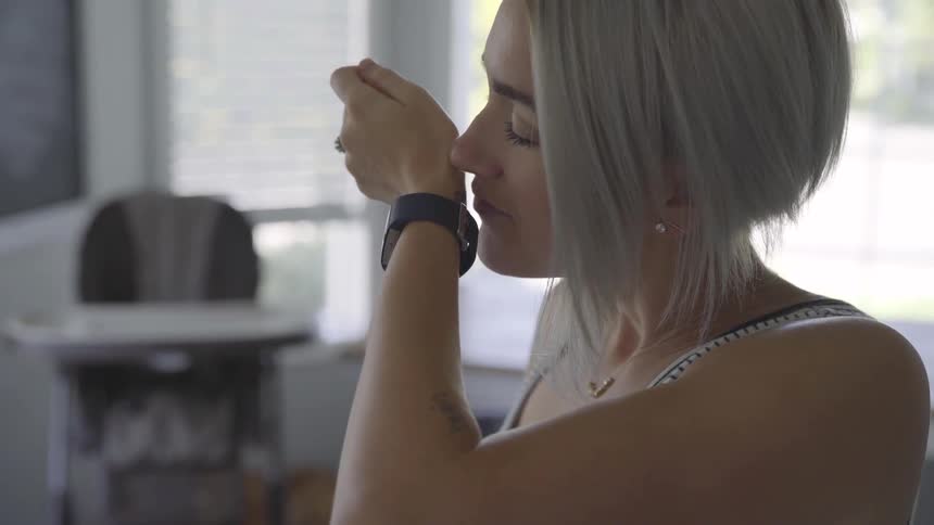 Woman smelling perfume applied to her wrist