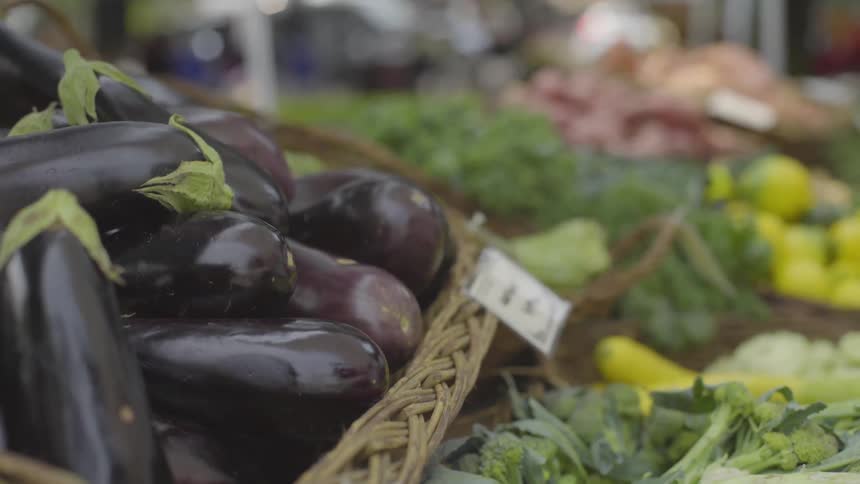 A basket of eggplants at a vegetable stand