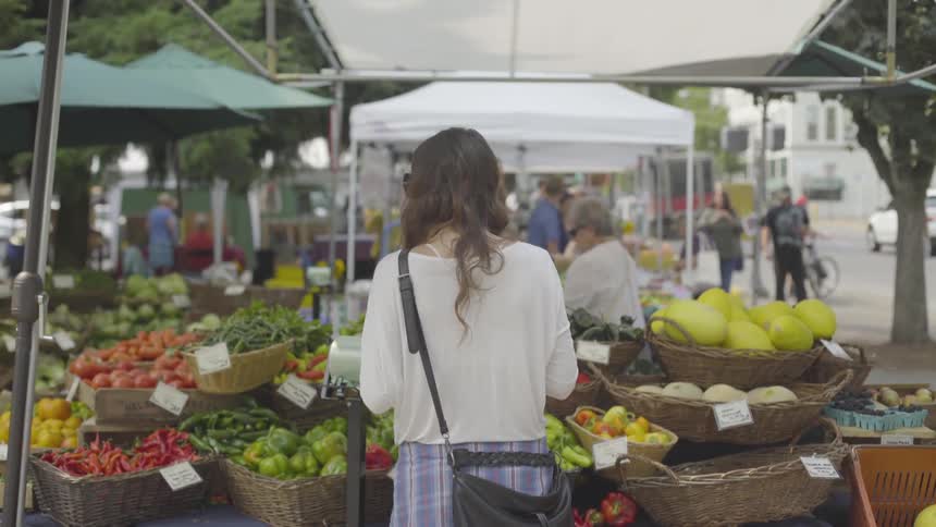A person is at a market looking at produce