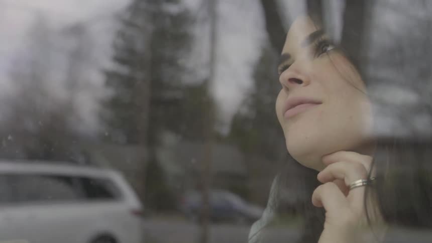 A woman is looking out a window