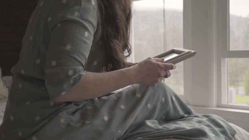 A woman is looking at a picture indoors