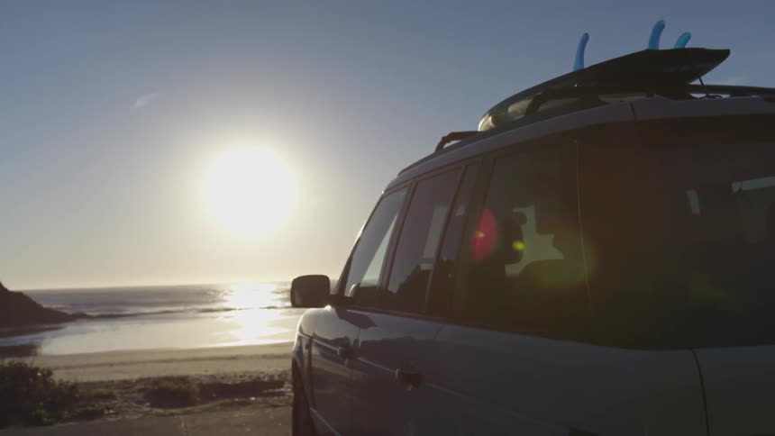 A sport utility vehicle is parked on the beach near the ocean