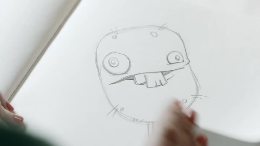 A woman drawing character animation on paper