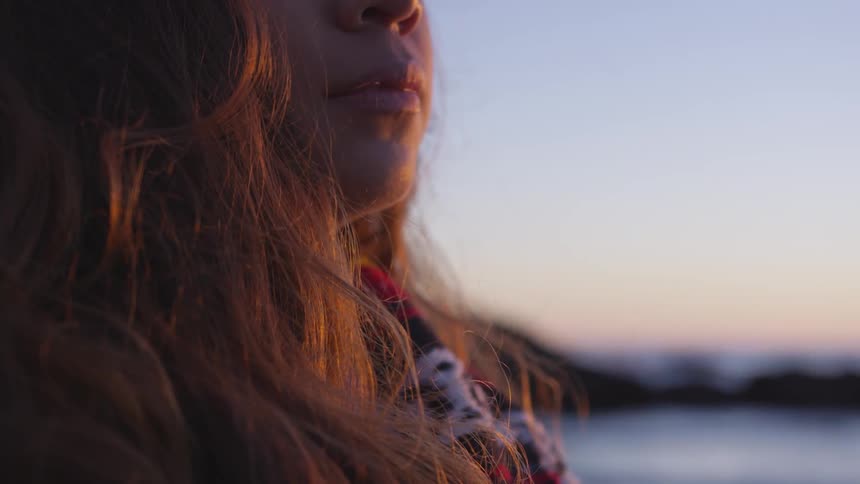 Woman stands next to the ocean