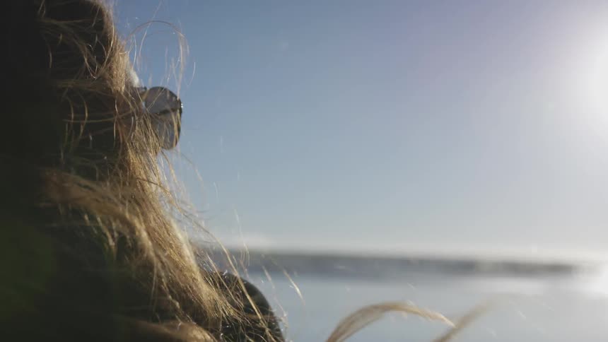 A woman staring out over the ocean during the day