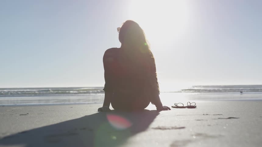 A woman resting on a beach on a sunny day
