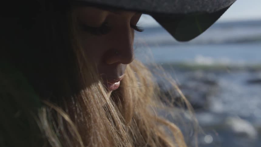 A woman is closing her eyes outdoors