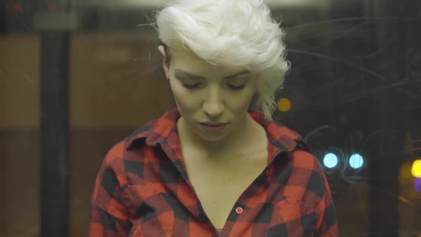 Short hair woman with her eyes closed while going down in the panoramic elevator