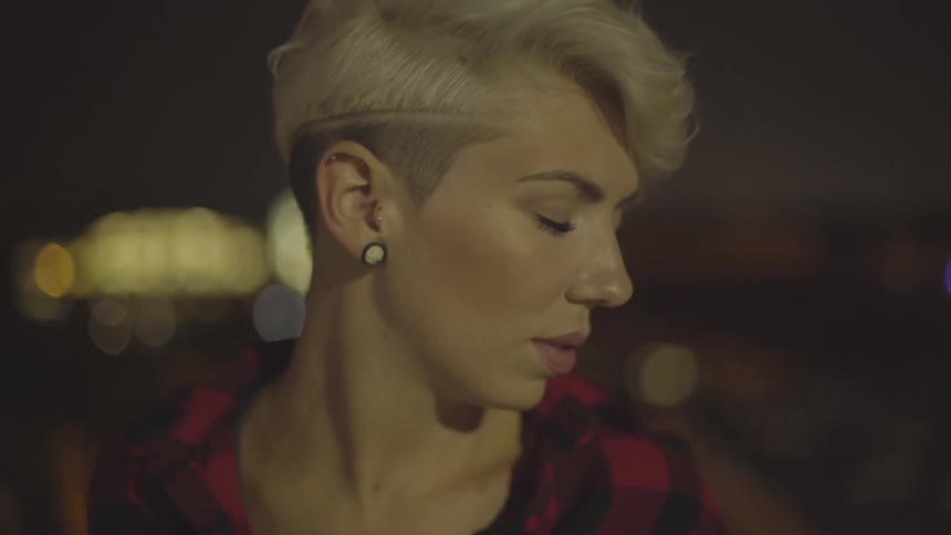 A woman displays the design of her haircut