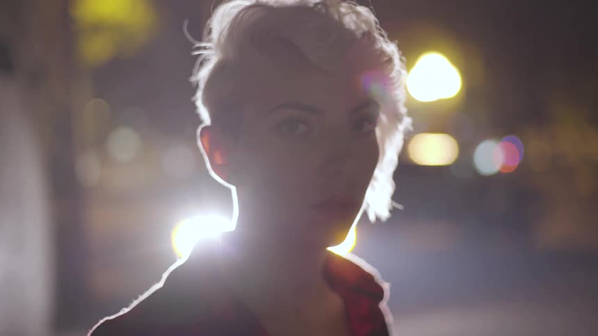 A woman is outside at night