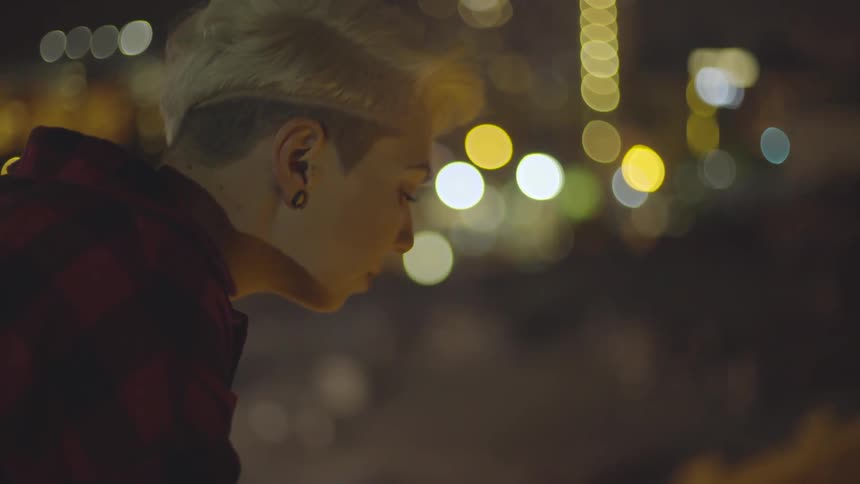 Woman sits thoughtfully as she looks around