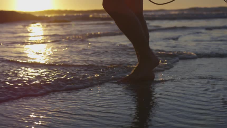 A person walking barefoot along the shore