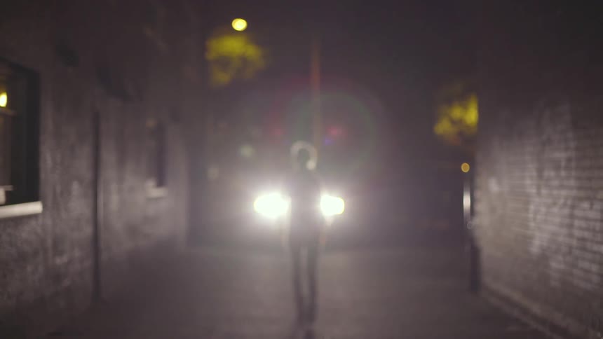 Person walking in front of head lights