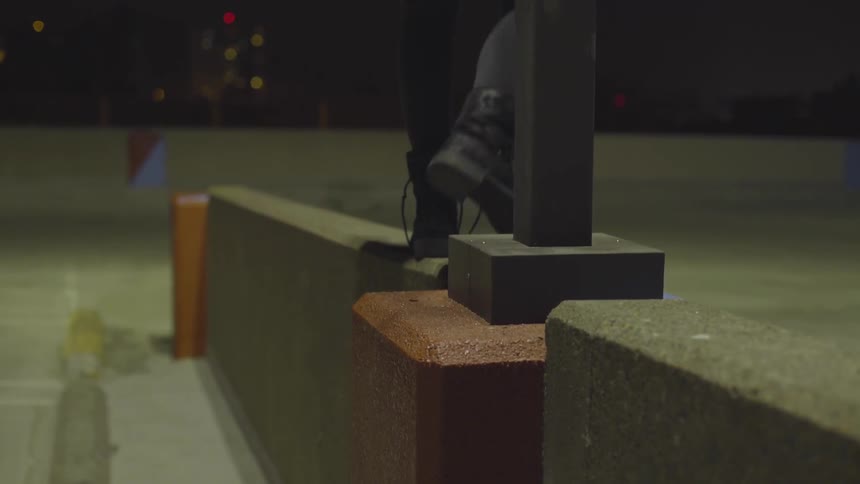 Person walks along a wall on top of a parking garage