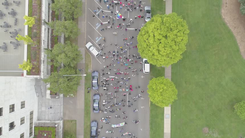 A crowd of people are walking in a city protesting