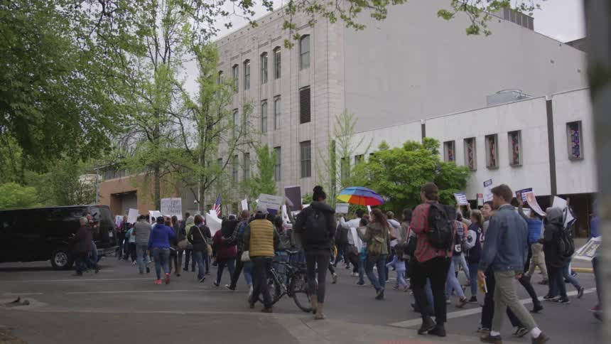 People hold signs and march during a protest
