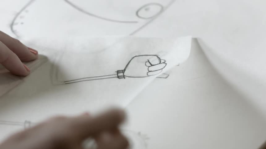Cartoonist checks their drawing by flipping a page