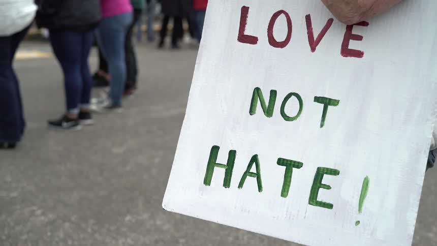 Person holding a love not hate sign at a rally