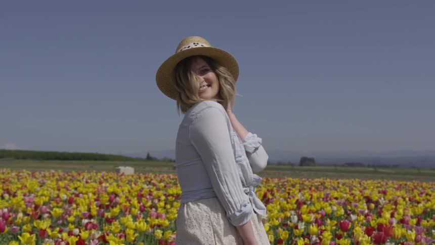 A woman posing in front of a field of tulips