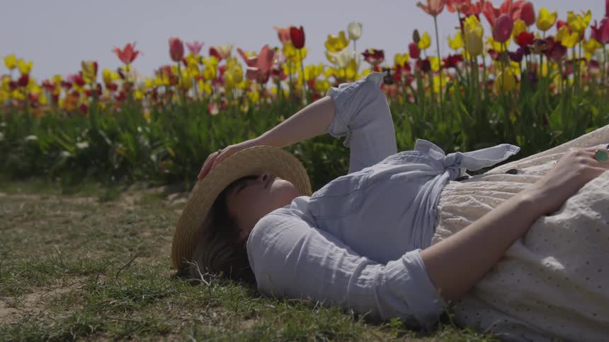 A woman resting on a field of tulips