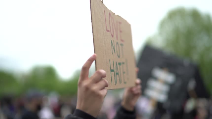 Protesters hold up signs