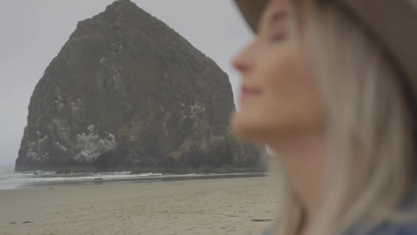 A woman is outside by the coast