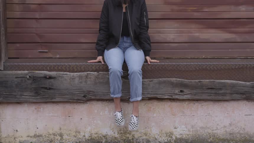 A woman sits on the edge of a loading bay